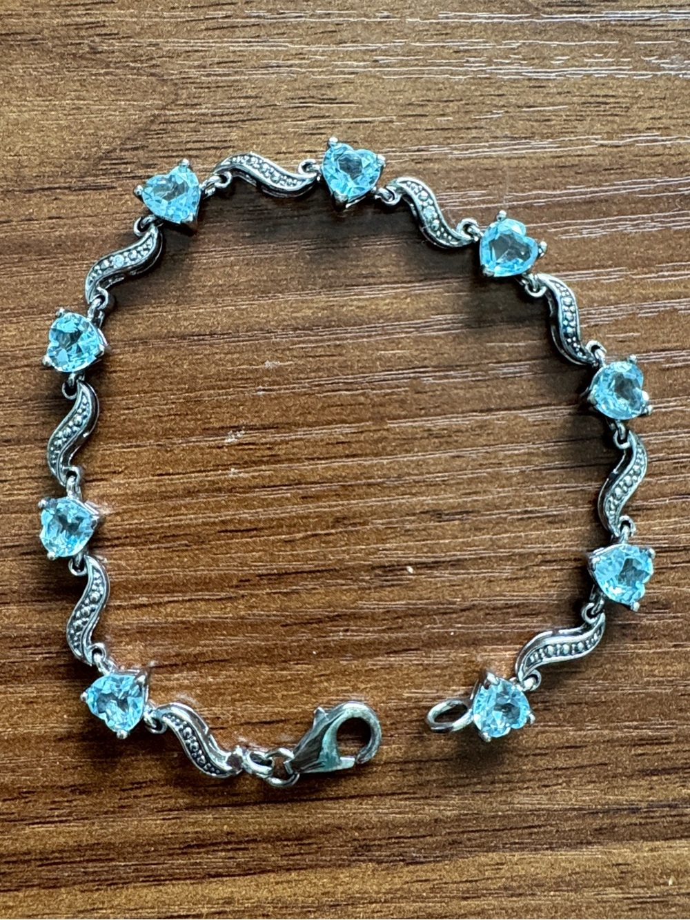 sterling silver tennis bracelet featuring heart-shaped blue gemstones